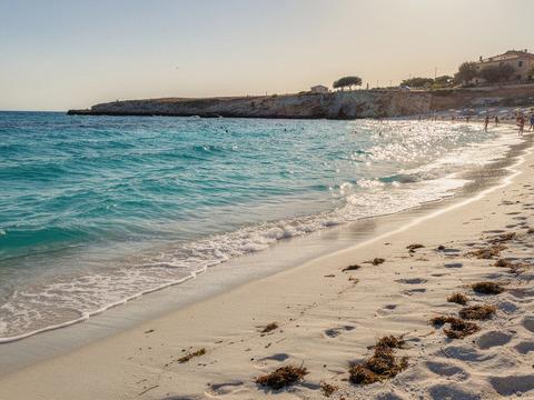 Shallow turquoise shoreline with gentle waves on a family beach